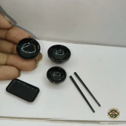 A complete black miniature dining set product featuring a table and four matching chairs arranged for a dollhouse scene.