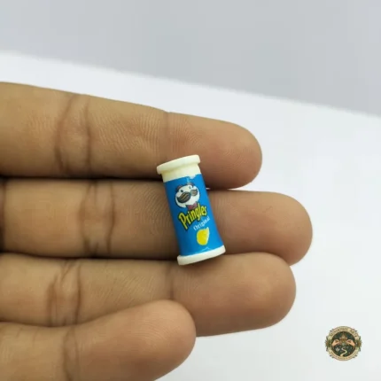 A hyper-realistic miniature Pringles can product, showcasing its vibrant red color and iconic branding in perfect 1:12 scale for dollhouses.