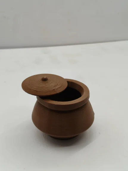A detailed miniature biriyani pot product, handcrafted from polymer clay with a sealed lid, shown against a neutral background for display.