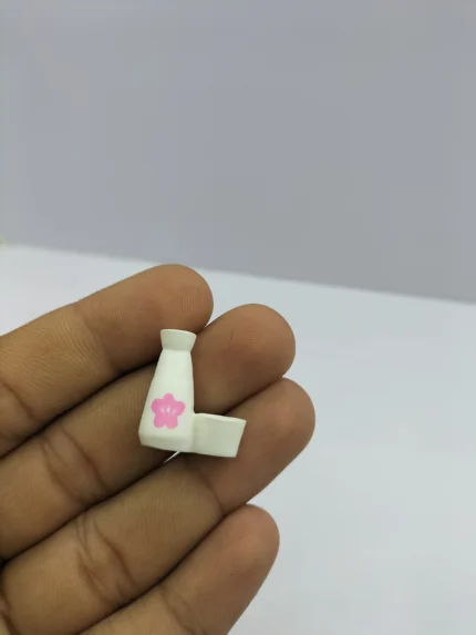 A detailed dollhouse flower vase product, crafted from white ceramic with a double opening designed to hold two tiny flower stems.