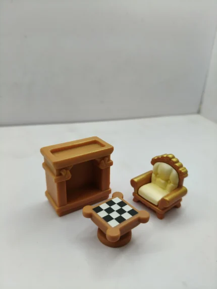 A detailed miniature living room set product featuring a tiny sofa, armchair, and coffee table with realistic fabric and wood finishes.