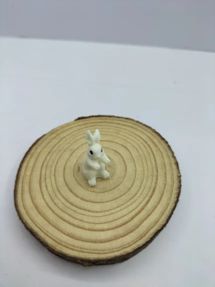 A hand-painted miniature rabbit figure product with detailed fur texture and a curious pose, designed for dollhouses or fairy gardens.