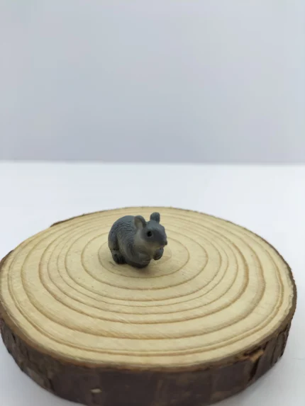 A lifelike miniature rat figurine product with detailed grey fur, a curious pose, and delicate whiskers, shown on a plain surface.