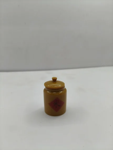 A miniature pickle jar product, showing tiny pickles suspended in liquid inside a clear glass jar with a metal lid.