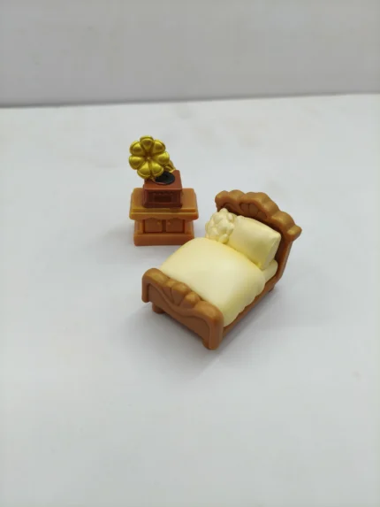 A miniature bedroom furniture set product, showcasing a detailed wooden bed with linens, two nightstands, and a dresser.