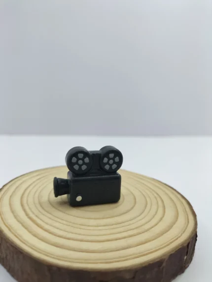A detailed vintage video recorder miniature product, showcasing its black retro body, realistic lens, and side viewfinder.