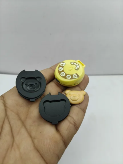 A miniature waffle maker product with a silver and black finish, shown on a kitchen counter for a 1:12 scale dollhouse scene.