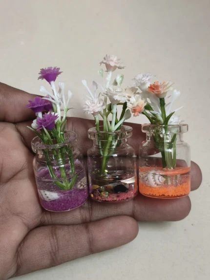 A delicate miniature glass flower pot, perfect for dollhouse gardens or miniature scenes, this product adds elegant