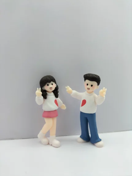A hand-painted couple miniature figurine product showing a man and woman in a friendly 'Hi' waving pose, perfect for home decor.