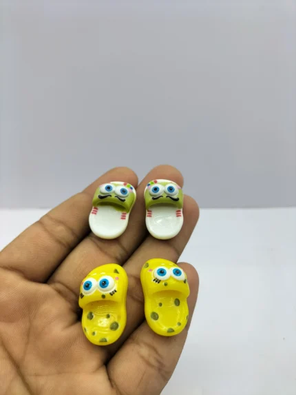 A pair of tiny, detailed dollhouse slippers product, showcasing their soft fabric texture and intricate stitching.