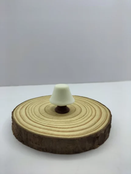 A charming miniature table lamp product with a detailed base and a soft, warm glowing lampshade, perfect for a desk or nightstand.