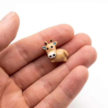 A detailed, hand-painted mini cow animal figurine product, perfect for miniature farm dioramas and collectors.