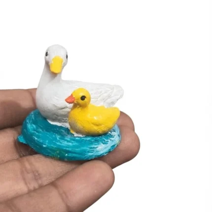 Charming resin duck and duckling miniature product with realistic water base, ideal for dioramas.
