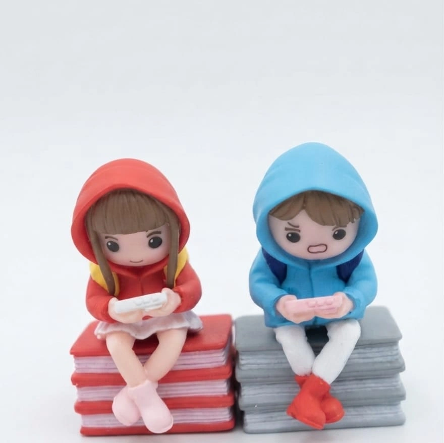 Gamer-Couple-on-Books-Chibi-Miniature-Figurine-Set-of-2 Chibi gamer couple figurine set of 2, a charming product sitting on miniature books, ideal for desk decor.