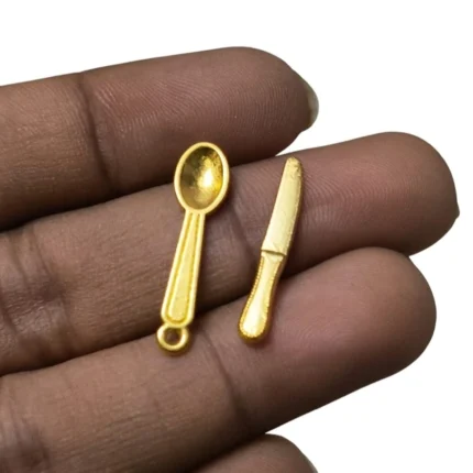 Beautifully crafted gold miniature cutlery set with tiny knife and spoon, ideal dollhouse product accessory.