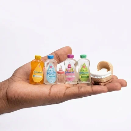 Miniature baby set product with tiny cradle, feeding bottle, and replica Johnson's items for dollhouse nurseries.