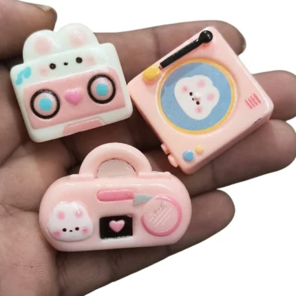 A vibrant, randomly selected kawaii music device resin flat-back miniature product, ideal for crafting and decor.