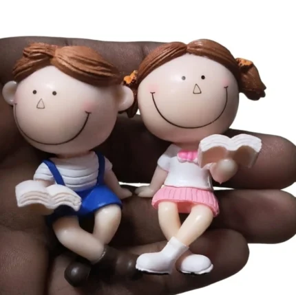 Charming miniature product: a reading couple figurine set in pink and blue, perfect for dollhouse scenes.