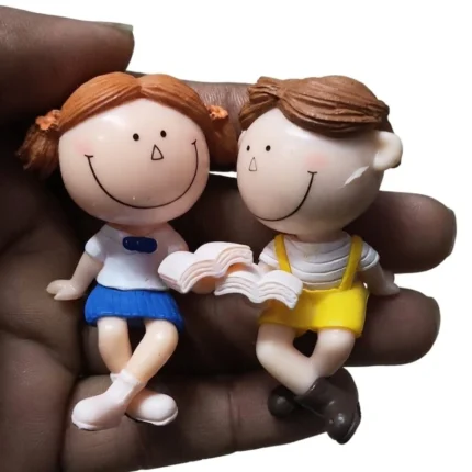 Charming miniature reading couple figurine set in yellow and blue. A delightful product for collectors.