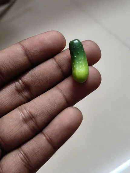 Highly detailed miniature cucumber figurine product for dollhouse kitchens, dioramas, or miniature food displays.