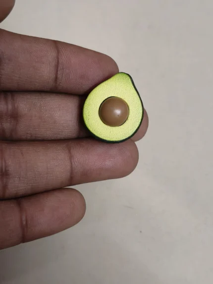 Detailed, handcrafted miniature halved avocado figurine product for dollhouse kitchens or tiny food displays.