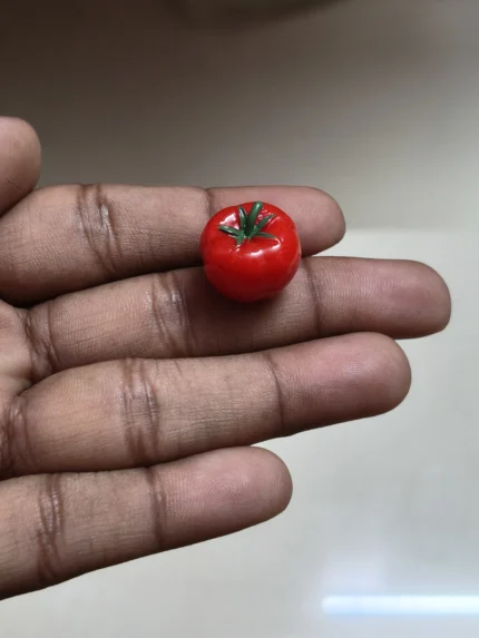 A highly detailed miniature red tomato figurine, a perfect product for dollhouse kitchens and food displays.