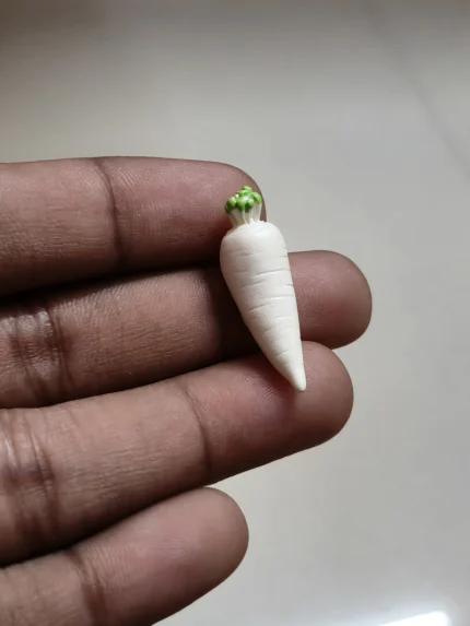 Detailed miniature white radish daikon figurine, a realistic product for dollhouse or miniature food displays.