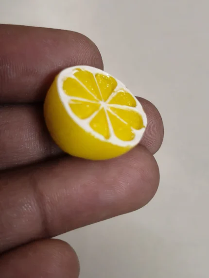 Highly detailed miniature halved lemon figurine, a perfect product for dollhouse kitchens and food displays.