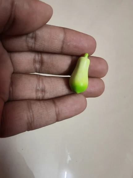 Handcrafted miniature green papaya fruit figurine product for dollhouse kitchens or diorama scenes.