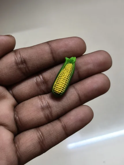 Detailed miniature corn cob figurine, a realistic product for dollhouse food displays and miniature scenes.