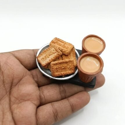This miniature product features a stack of Parle-G biscuits next to a tiny clay kulhad filled with chai.