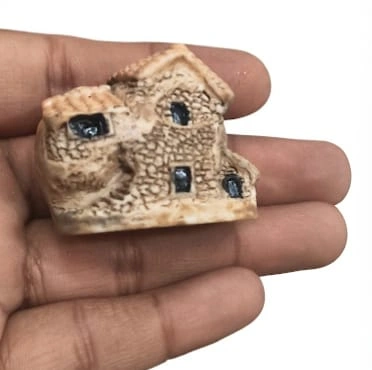 Detailed resin rustic stone cottage miniature product with textured roof, quaint windows, ideal for fairy gardens.