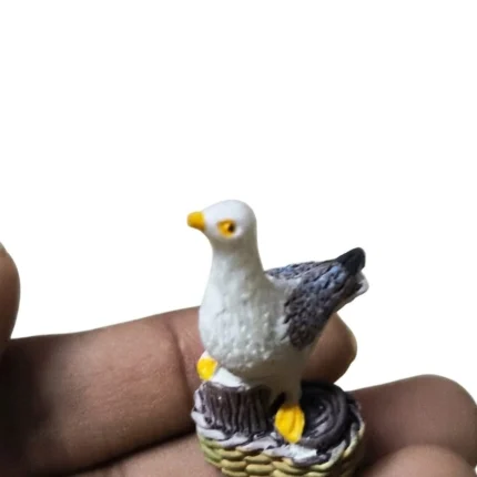 Charming seagull resin miniature bird figurine on a nest base, a delightful product for collectors and crafters.