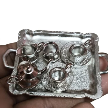 This product is a finely crafted silver metal miniature tea set with a tray, perfect for dollhouse displays.