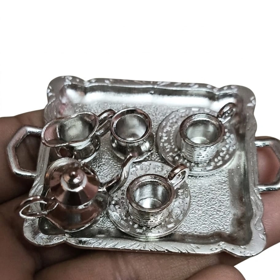 Silver-Metal-Miniature-Tea-Cup-and-Saucer-Set-with-Tray This product is a finely crafted silver metal miniature tea set with a tray, perfect for dollhouse displays.
