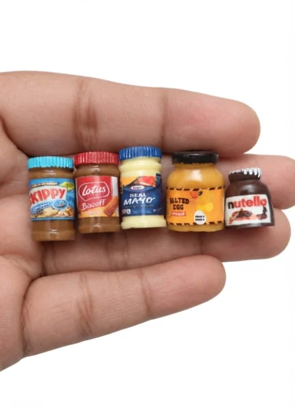 This product features 5 tiny miniature food spread jars, ideal for dollhouse kitchens or diorama displays.