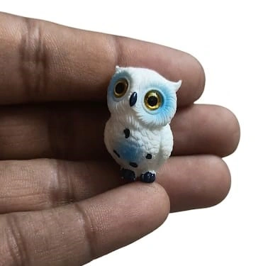 This beautiful white and blue miniature owl figurine with striking golden eyes is a charming decorative product.