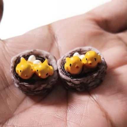 Miniature bird nest product with tiny chicks and eggs, ideal for dollhouse scenes or nature dioramas.