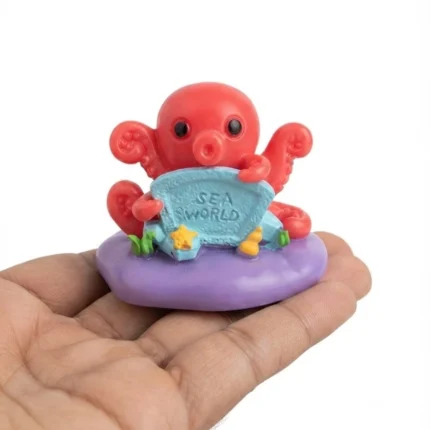 Vibrant miniature red octopus figurine product with 'Sea World' sign, perfect for dollhouses or aquatic dioramas.