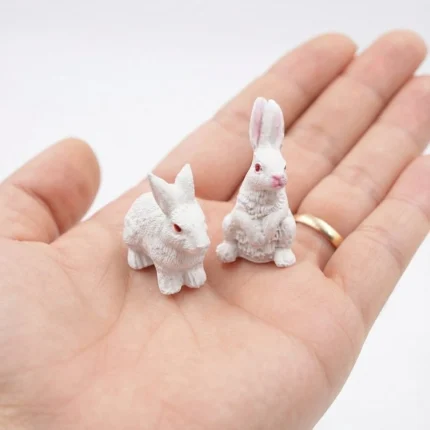 Product: A set of two miniature white rabbit figurines, ideal for dollhouse scenes or fairy gardens.