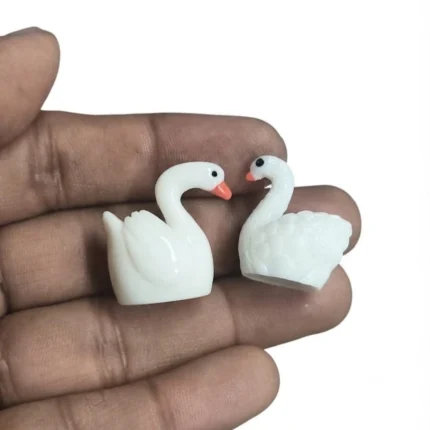 A beautiful miniature white swan figurine set of two, perfect for enhancing any dollhouse or diorama product scene.