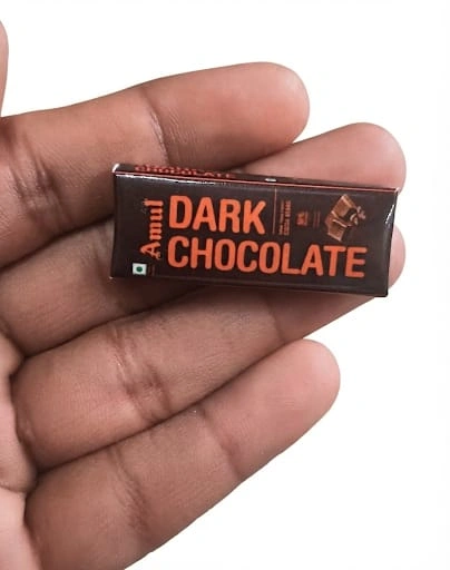 A highly detailed miniature replica product of an Amul dark chocolate bar, perfect for collectors and display.