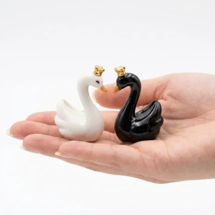 This product is an elegant black and white swan miniature figurine set, each adorned with a gold crown.