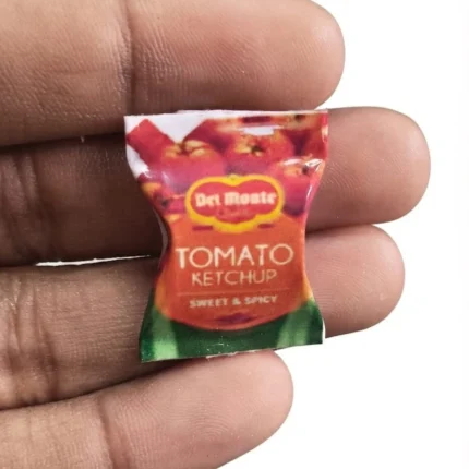 Detailed miniature Del Monte tomato ketchup sachet product, perfect for dollhouse scenes and tiny food collections.