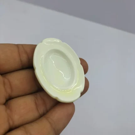 A beautiful cream miniature ceramic oval plate, a perfect dollhouse kitchenware product for realistic tiny scenes.
