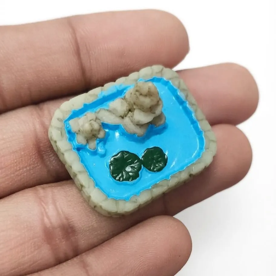 Miniature-Koi-Pond-with-Rocks-and-Lotus-Leaves Beautifully crafted miniature koi pond product featuring realistic rocks and delicate lotus leaves.