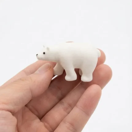 A charming miniature white polar bear animal figurine product, perfect for collectors and diorama enthusiasts.