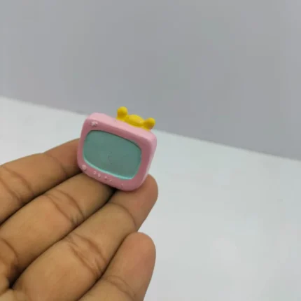 A charming pink miniature retro television figurine, a delightful product for dollhouse enthusiasts and collectors.