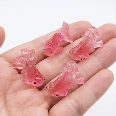 Pink resin goldfish miniature figurine, a unique and randomly selected product for whimsical display.
