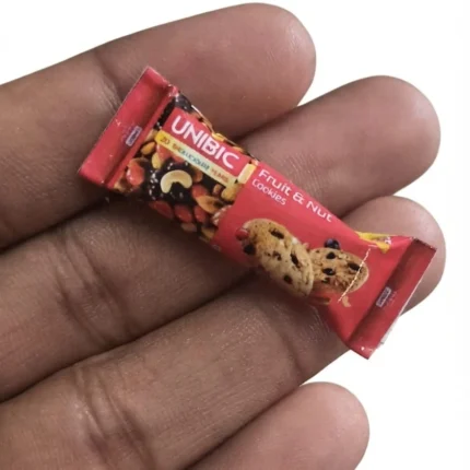 A detailed miniature product replica of Unibic Fruit and Nut Cookies pack, perfect for dollhouse scenes.
